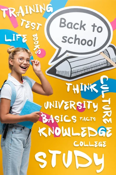 Colegial con mochila y anteojos de pie al lado de la burbuja del habla con letras de vuelta a la escuela y artesanía de papel en amarillo - foto de stock