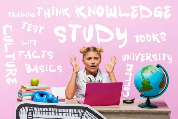 Worried kid looking at camera near laptop, books, paper art, globe, retro telephone and lettering on pink — Stock Photo