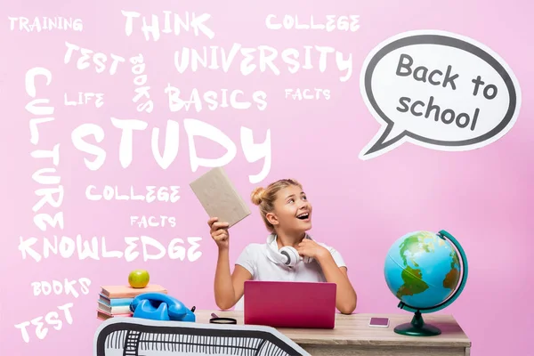 Colegiala sosteniendo libro y mirando la burbuja del habla con letras de vuelta a la escuela cerca de gadgets, globo e ilustración en rosa - foto de stock
