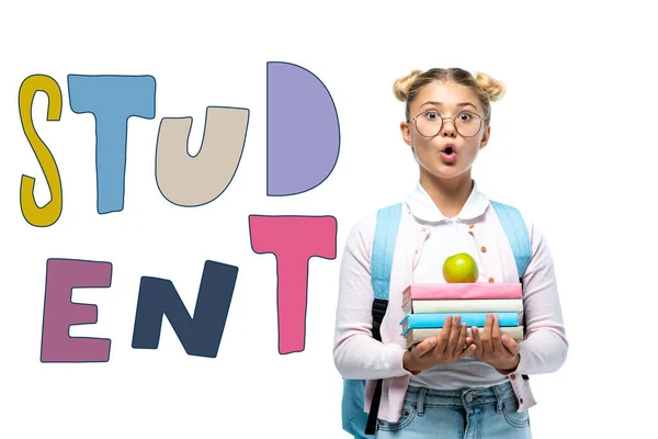 Shocked schoolgirl holding apple and books near student lettering on white — Stock Photo