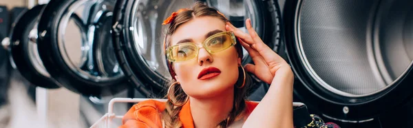 Pensive woman near washing machines in public laundromat, banner — Stock Photo