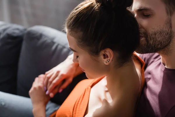 Zarter Mann küsst Kopf seiner aufgebrachten Freundin, während er sie zu Hause beruhigt — Stockfoto