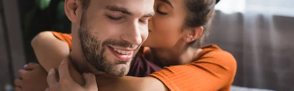 Tendre femme embrassant petit ami heureux et chuchotant dans son oreille, bannière — Photo de stock