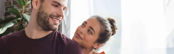 Smiling woman looking at cheerful boyfriend from back, banner — Stock Photo