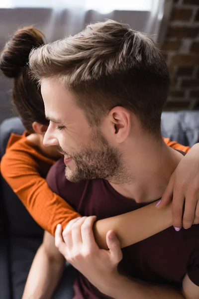 Homem feliz abraçado por terna namorada em casa — Fotografia de Stock