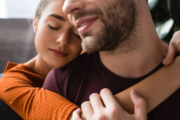 Mulher feliz abraçando sorridente amado homem em primeiro plano borrado — Fotografia de Stock