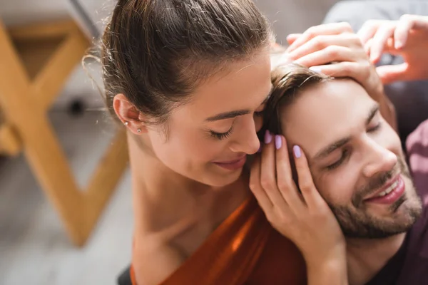 Ansicht der glücklichen Frau, die den Kopf ihres geliebten Mannes mit geschlossenen Augen berührt — Stockfoto