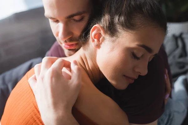 Reaktionsfähiger Mann umarmt geliebte Frau mit geschlossenen Augen — Stockfoto