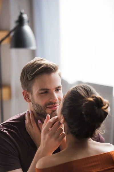 Rückansicht einer jungen Frau, die lächelnden Mann berührt, während sie einander ansieht — Stockfoto