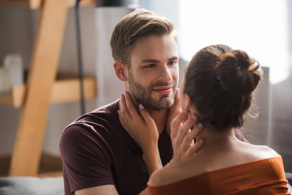 Pareja joven tocándose mientras están de pie cara a cara en casa - foto de stock