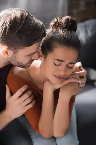 Giovane uomo abbracciare depresso fidanzata mentre calmante sentire a casa — Foto stock
