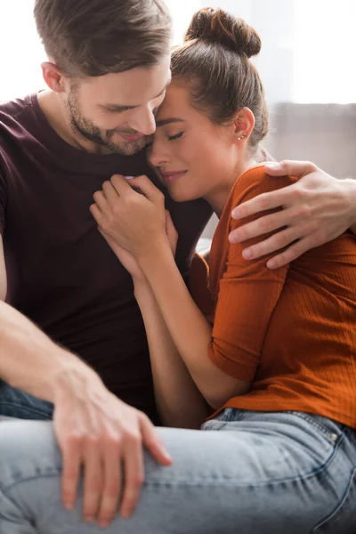 Joven hombre abrazando molesto novia mientras que la calma en casa - foto de stock