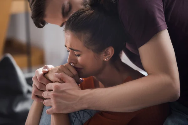 Jeune homme touchant les mains et embrassant la tête de pleurer, femme déprimée — Photo de stock