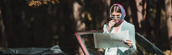 Femme en foulard et lunettes de soleil regardant la carte près de la voiture à l'extérieur, bannière — Photo de stock