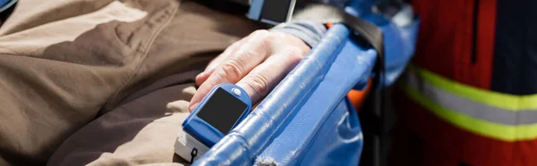 Website header of senior man with heart rate monitor lying on stretcher — Stock Photo