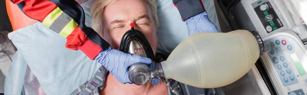 Website header of paramedic doing cardiopulmonary resuscitation to sick patient in ambulance car — Stock Photo