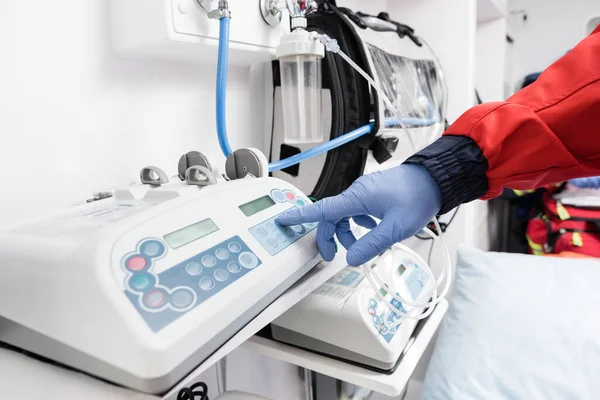 Vista recortada de paramédico en guante de látex usando equipo en ambulancia auto - foto de stock