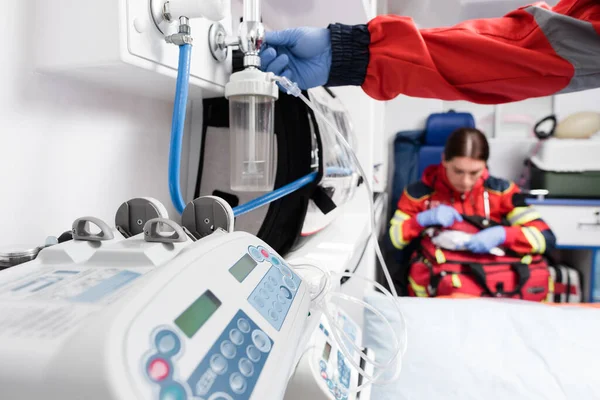 Focus selettivo del paramedico utilizzando nebulizzatore vicino alle apparecchiature in auto ambulanza — Foto stock