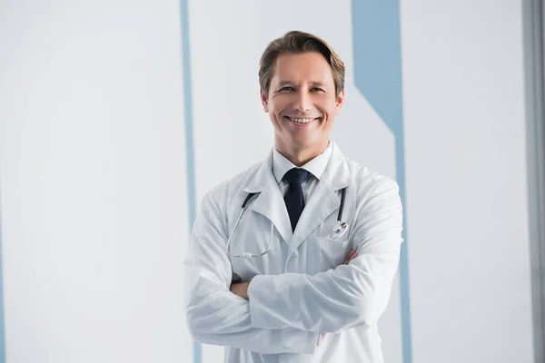 Doctor with crossed arms looking at camera in clinic — Stock Photo