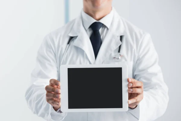 Vue recadrée du médecin montrant la tablette numérique en clinique — Photo de stock