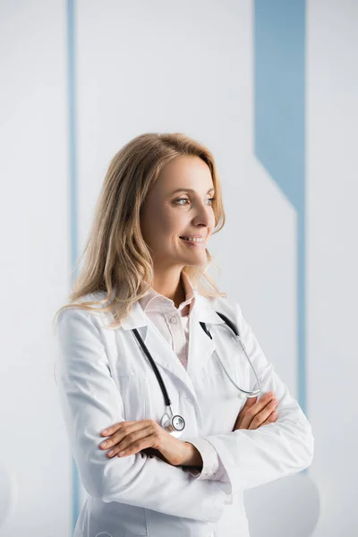 Doctor with crossed arms looking away in hospital — Stock Photo