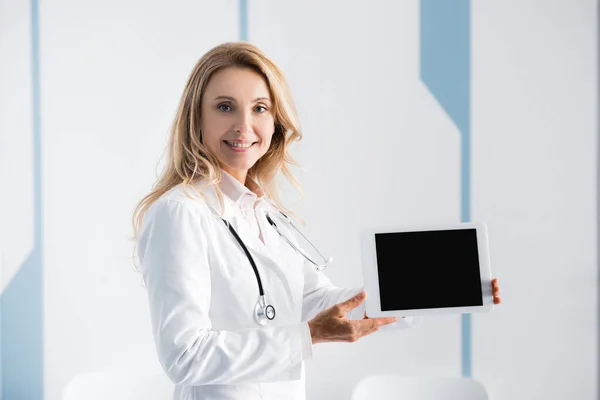 Médico apontando com a mão para tablet digital na clínica — Fotografia de Stock