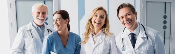 Panoramic orientation of hospital staff looking at camera in clinic — Stock Photo