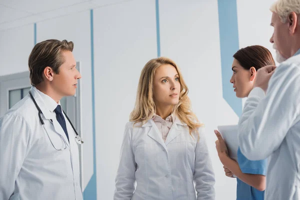 Enfoque selectivo de médicos y enfermeras con tableta digital hablando en el hospital - foto de stock