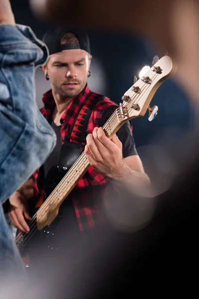 KYIV, UKRAINE - 25 AOÛT 2020 : Musicien d'un groupe de rock jouant de la guitare électrique au premier plan flou — Photo de stock