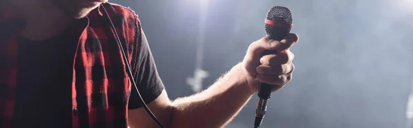 Vista recortada do vocalista da banda de rock segurando microfone no fundo embaçado, banner — Fotografia de Stock