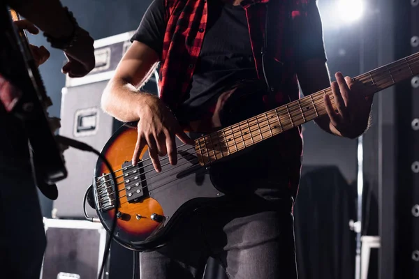 KYIV, UCRAINA - 25 AGOSTO 2020: Vista ritagliata del musicista che suona il basso con chitarrista sfocato sullo sfondo — Foto stock