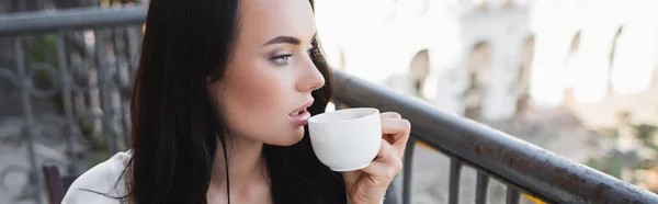 Belle femme brune buvant du café et regardant ailleurs, bannière horizontale — Photo de stock