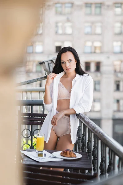 Woman in white shirt and beige underwear posing on balcony — Stock Photo