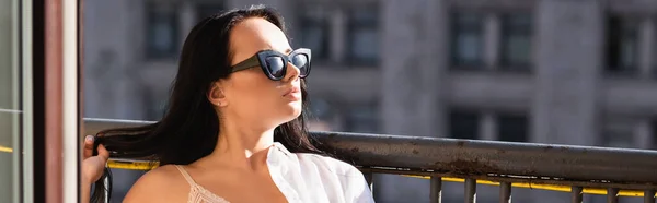 Morena mujer en gafas de sol tomando el sol en el balcón, pancarta horizontal - foto de stock