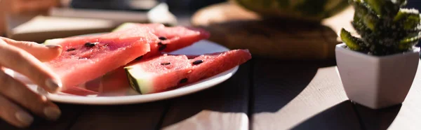 Teller mit Wassermelonenscheiben auf Vorder- und Frauenhand, horizontales Banner — Stockfoto