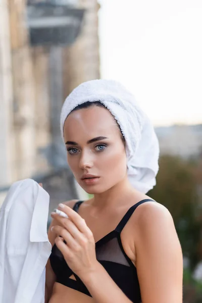 Sexy young woman in black underwear with towel on head smoking cigarette on balcony — Stock Photo
