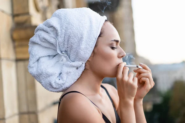 Jovem sexy em roupa interior preta com toalha na cabeça fumar cigarro na varanda — Fotografia de Stock