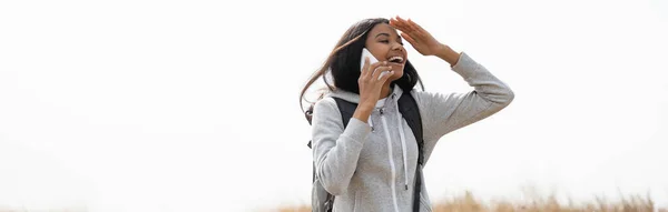 Веселый африканский американский турист разговаривает по смартфону на открытом воздухе, баннер — стоковое фото