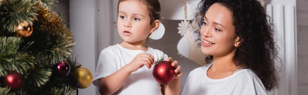 Panoramaaufnahme von Mutter und Tochter beim Dekorieren von Weihnachtskiefern am Kamin — Stockfoto