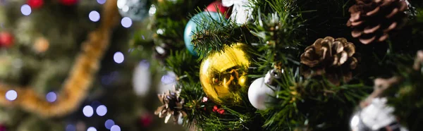 Panoramic shot of decorated spruce with christmas balls and pine cones — Stock Photo