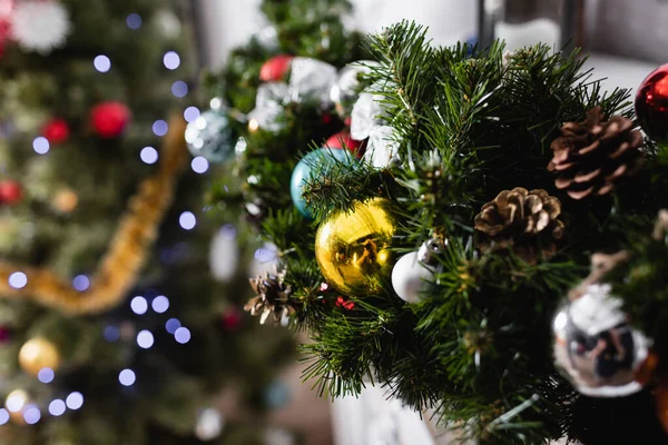 Selective focus of pine branch with christmas balls and pine cones — Stock Photo