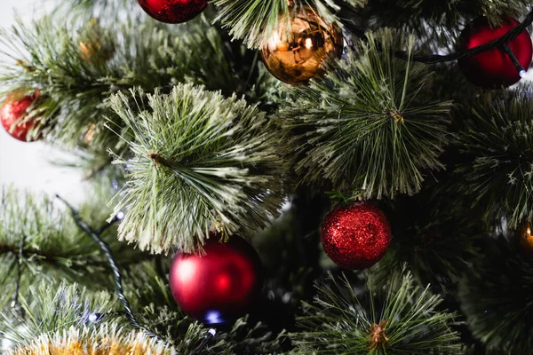 Close up view of pine with christmas balls and lights — Stock Photo