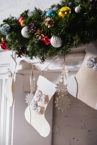 Chimenea decorada con medias de Navidad, ramas de pino y bolas de Navidad - foto de stock