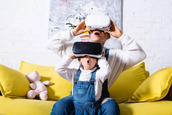 Aufgeregte Mutter und Tochter nutzen Virtual-Reality-Headsets zu Hause — Stockfoto