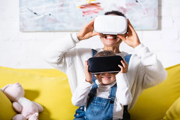 Focus selettivo di madre e figlia utilizzando cuffie realtà virtuale a casa — Foto stock