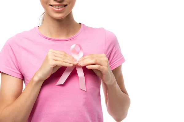 Vista recortada de una mujer joven que sostiene la cinta de conciencia del cáncer de mama aislada en blanco - foto de stock