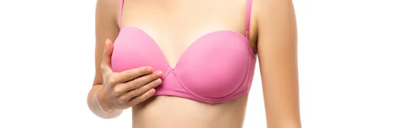 Image horizontale d'une jeune femme touchant le sein en soutien-gorge rose isolé sur blanc, concept de cancer du sein — Photo de stock