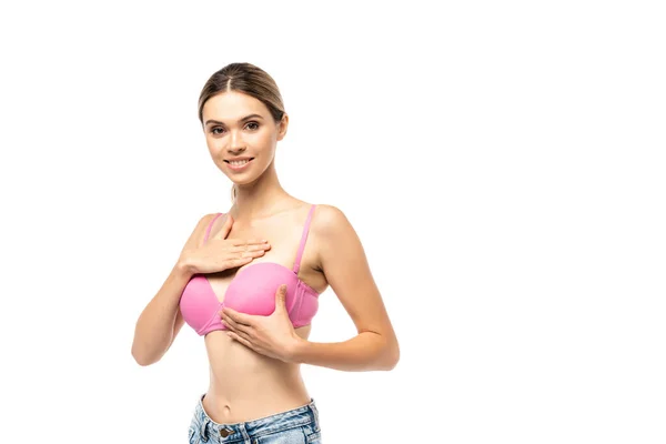 Концепція раку молочної залози з брюнеткою жінка торкається грудей в рожевому бюстгальтері ізольована на білому — стокове фото
