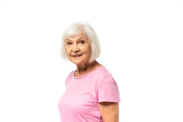 Grauhaarige Frau im rosafarbenen T-Shirt, die in die Kamera blickt, isoliert auf weiß, Konzept von Brustkrebs — Stockfoto