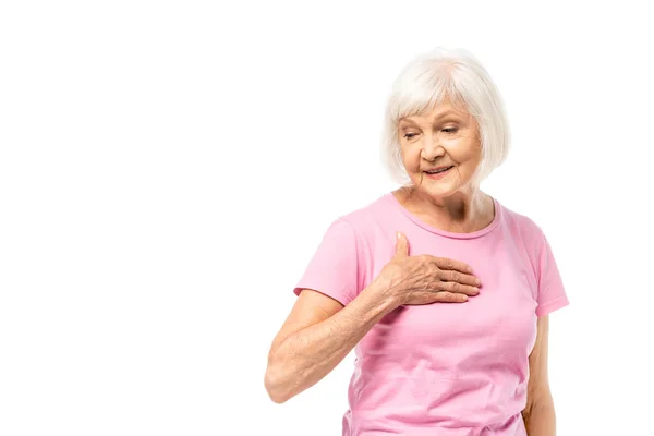 Elderly woman in pink t-shirt touching chest isolated on white, concept of breast cancer — Stock Photo